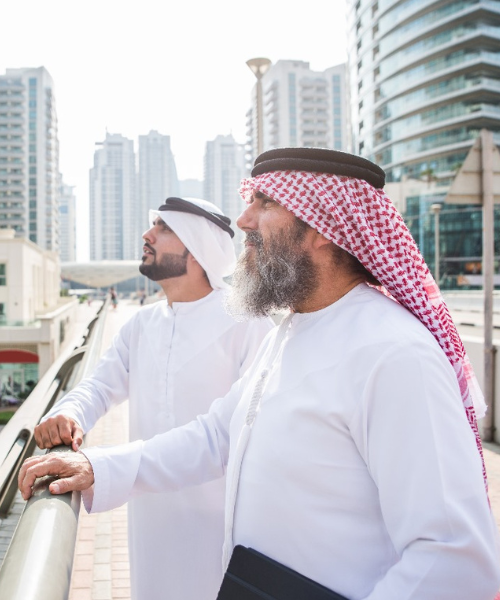 Two Arab businessmen observing cityscape, symbolizing growth and urban development.