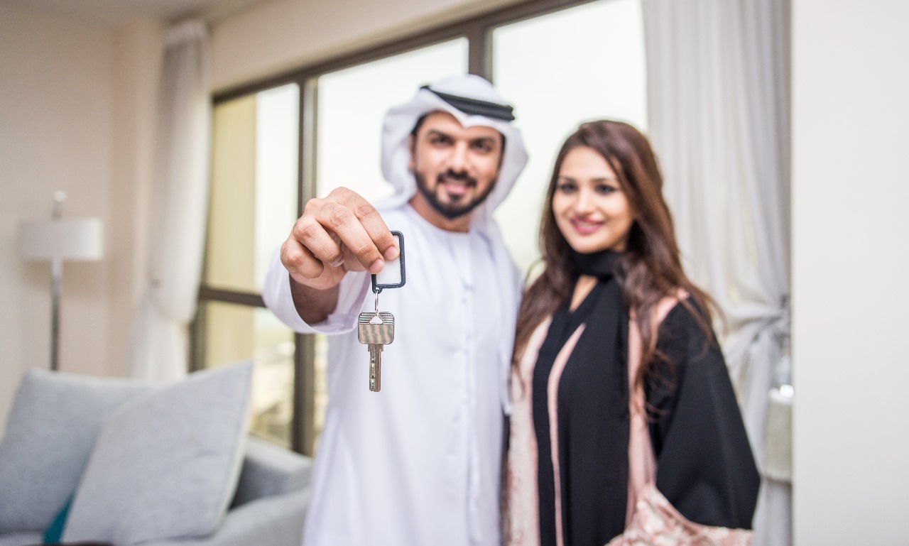Happy couple receiving house keys, symbolizing trust and integrity in real estate service.