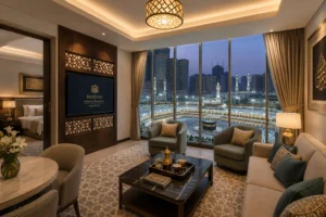 A high-end, contemporary serviced apartment interior in Makkah with floor-to-ceiling windows overlooking the Haram, featuring luxury Arabic decor accents, warm lighting, and modern furnishings
